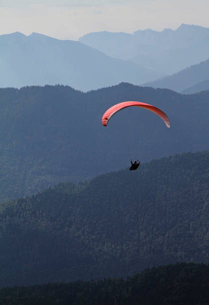 istock Paraglider in front of spectacular mountain range 1015387864