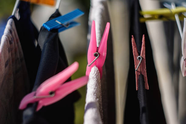 istock Close-Up Of Plastic Clothespins Holding Clothes On Wire For Drying 1015388104