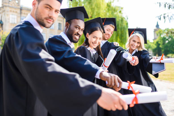istock young graduated students holding rolled diplomas 1015393808