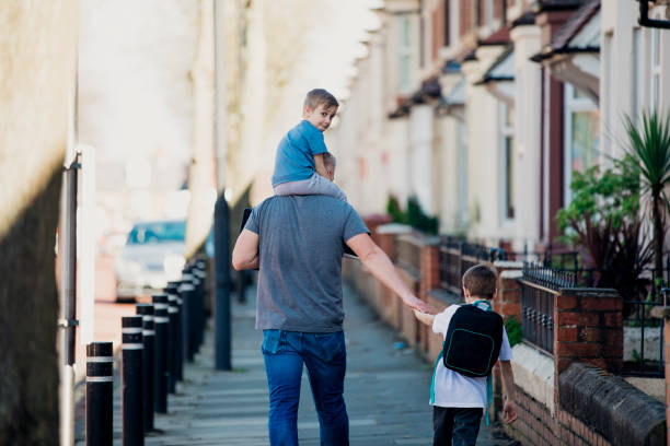 istock Man Walking Down the Street with his Sons 1015394388