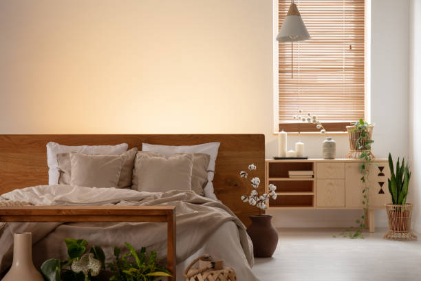 istock Empty wall in a bedroom interior with a double bed, pillows, cabinet and window blinds. Real photo 1015394744