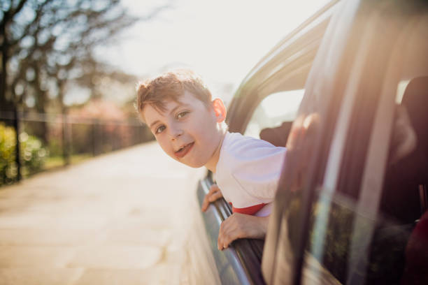 istock Boy Leaning Out of a Car Window 1015394756