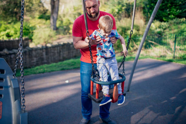istock Helping his Son on the Swings 1015399214