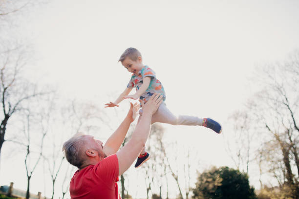 istock Throwing his Son into the Air in the Park 1015399314