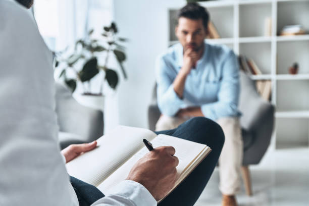 Making profile. Young frustrated man solving his mental problems while having therapy session with psychologist images of divorce stock pictures, royalty-free photos & images