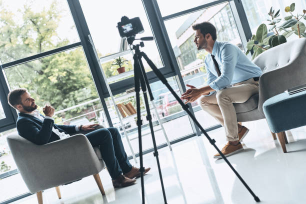 Creating interesting content. Two young men in smart casual wear talking while making new video indoors camera photographic equipment stock pictures, royalty-free photos & images