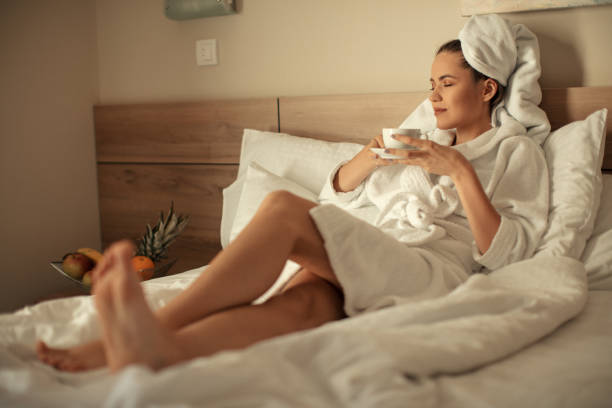 istock Young woman on bed wrapped in towel 1015404818