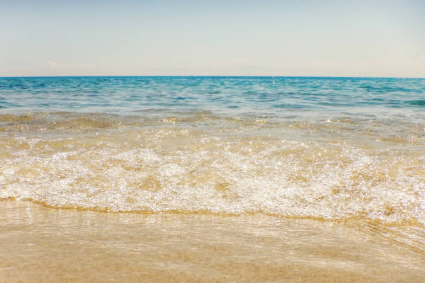istock Wave of blue ocean on sandy beach Summer Background 1015408762