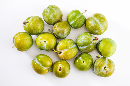 Delicious green plums fresh and raw claudias. Isolated on white background.