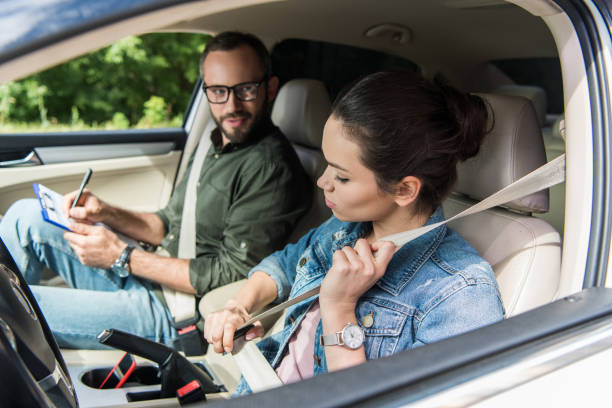 student fastening seat belt in car during driving test student fastening seat belt in car during driving test driving test photos stock pictures, royalty-free photos & images