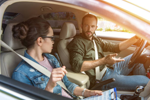 istock student and teacher looking at each other in car at driving test 1015409670