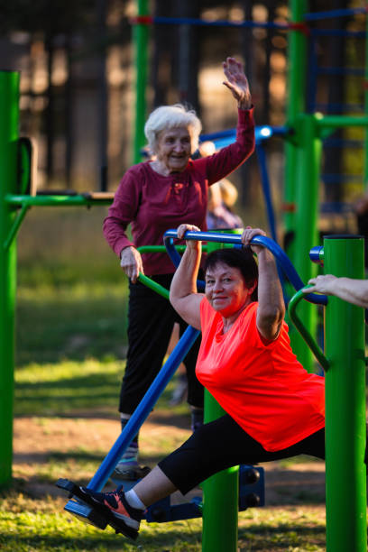 starsza kobieta wykonuje ćwiczenia na sportowym placu zabaw w parku. - 16326 zdjęcia i obrazy z banku zdjęć