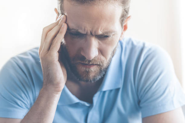 istock Tired Young Man in Casual Clothes Touching Temple. 1015413554