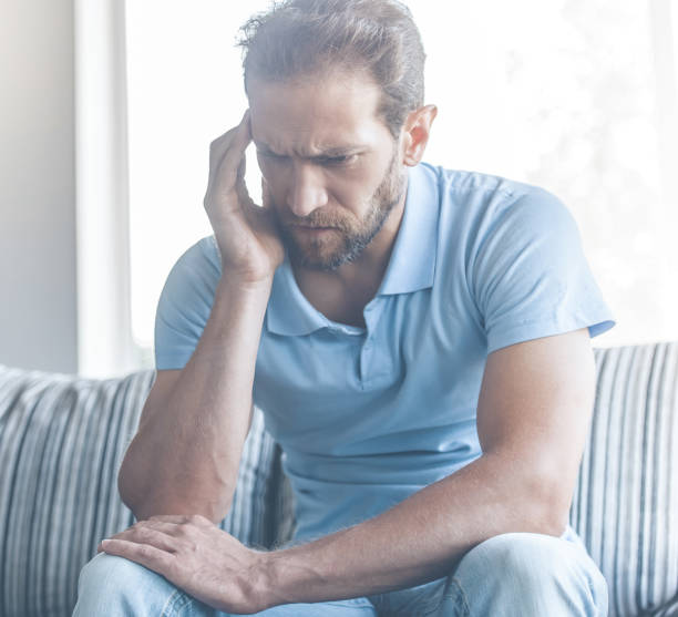 istock Tired Young Man in Casual Clothes Touching Temple. 1015413560