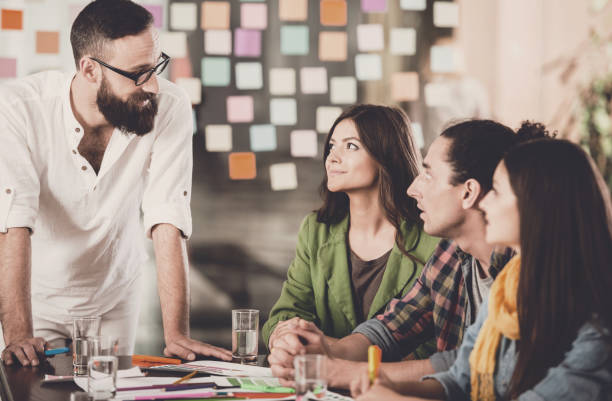istock Group of Young Designers Discuss New Project. 1015414432