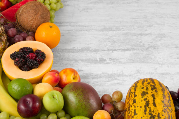 istock Fresh Fruits on White Wooden Background 1015414492