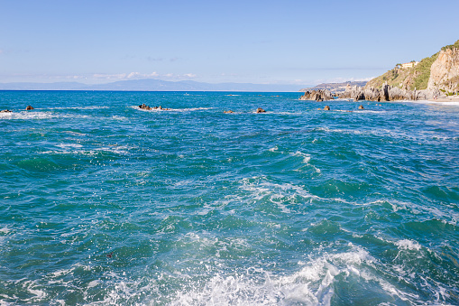 Mediterranean seascape, blue sea, rocks on the coast, summer day. Calabrian beach, near Tropea