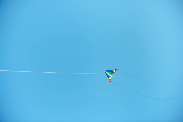 istock colorful kite flying high in blue clear sky 1015430170