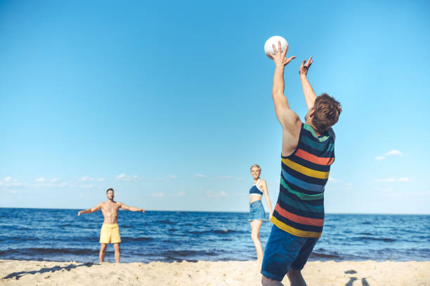 istock young friends playing volleyball together on sandy beach 1015430350