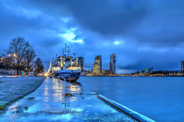 Rotterdam, The Netherlands, January 12, 2016: View along Park Quay (Parkkade) towards Wilhelminapier under a cloudy sky before sunrise
