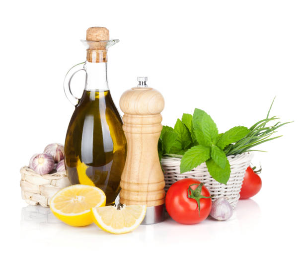 Fresh herbs, tomato, olive oil and pepper shaker. Isolated on white background