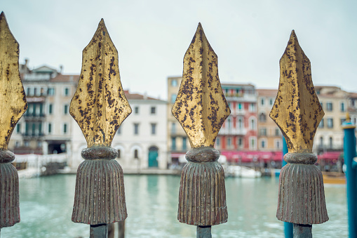 rusty vintage metallic spikes of channel fence in Venice, Italy