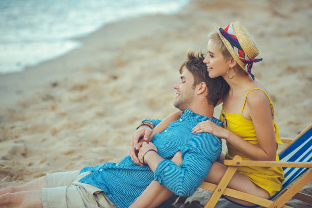 istock side view of young couple resting on beach on summer day 1015438952