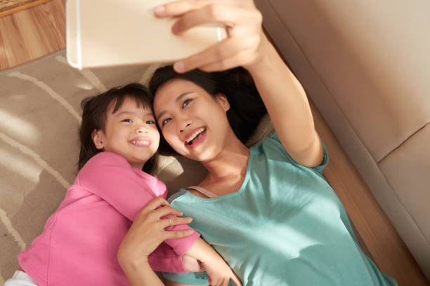 Happy woman taking selfie with daughter