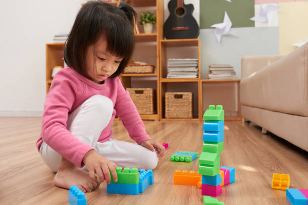 istock Little girl playing with colorful block 1015443900