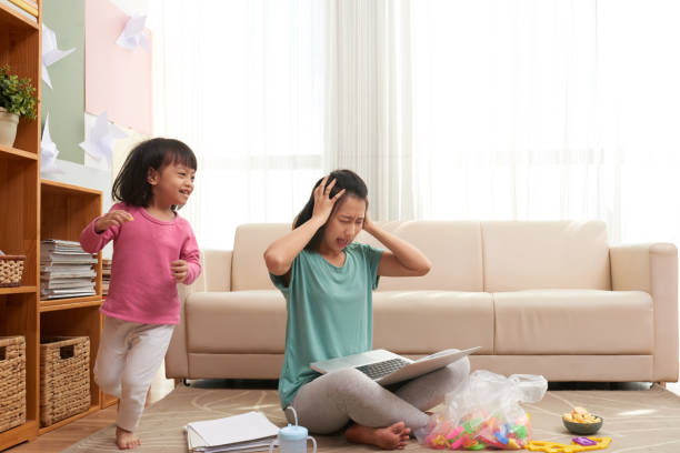 стресс женщина работает дома с шумным ребенком - banging your head against a wall audio стоковые фото и изображения