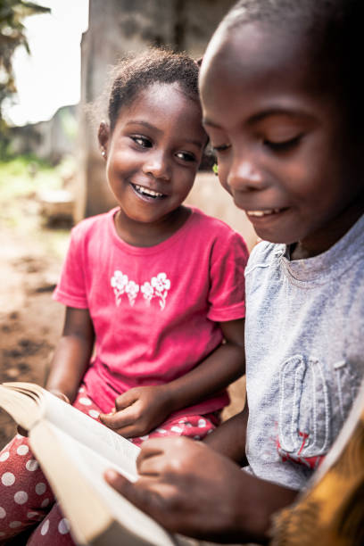 istock African child  reading a book outdoors 1015447680