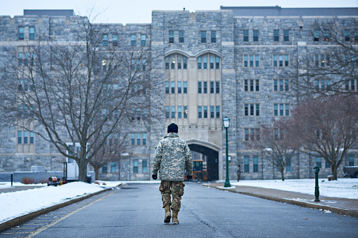 Rearview shot of a young soldier walking to the entrance of an academy