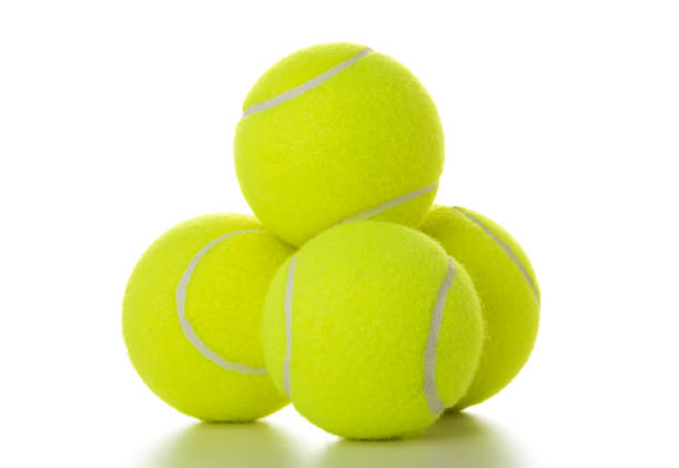 Three bouncing yellow balls in blurred motion. Two are tennis balls and one is a bouncy rubber ball. The shadows of the balls can be seen on the neutral background.