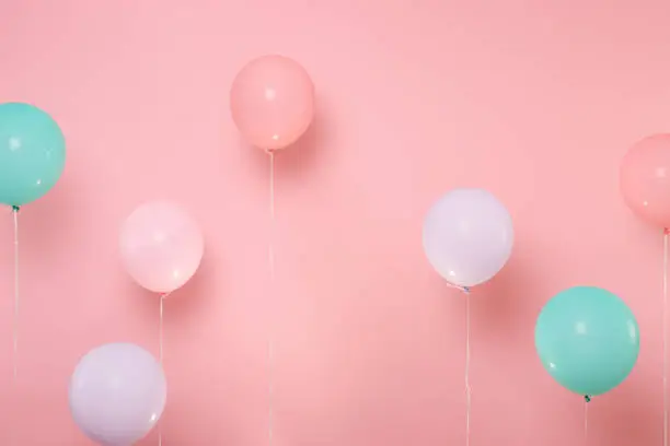 Colorful air balloons on pastel bright trending pink background. Decoration for birthday holiday party concept