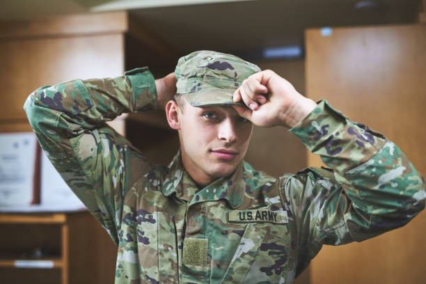 In a world where you can be anything, be brave Shot of a young soldier standing getting dressed in the dorms of a military academy infantry stock pictures, royalty-free photos & images