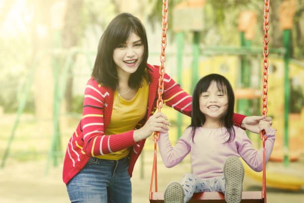 istock Mother and daughter play together at playground. 1015451844