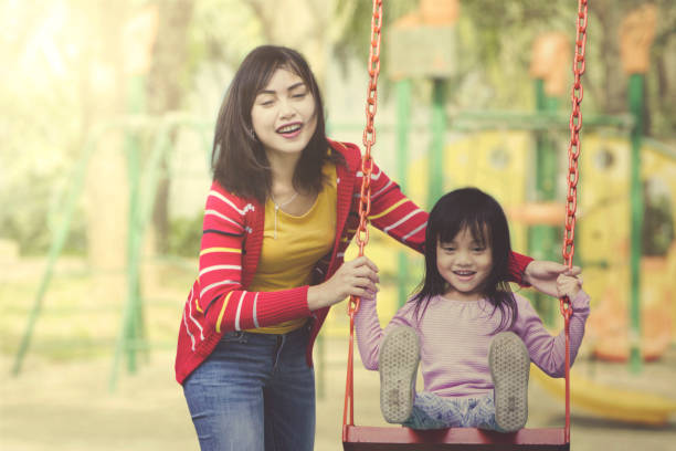 istock Mother and daughter play together at playground. 1015451886