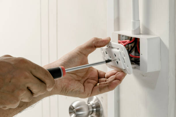 Home electrical system The electrician is using a screwdriver to attach the power cord to the wall outlet. electrician stock pictures, royalty-free photos & images