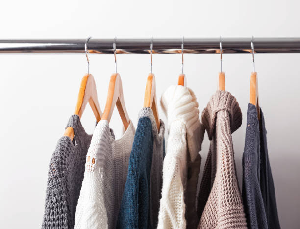 istock Knitted sweaters on hangers on the white wall background 1015455294