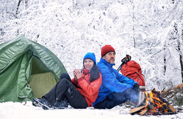 istock Winter camping in the forest with a tent and a fire. 1015456280