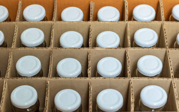 istock Glass bottles with white bottle caps in a cardboard box, Top view, Packaging concept. 1015461842
