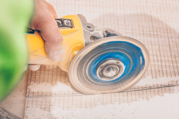 istock Finishing works - the tiler professionally and qualitatively cuts the tile with an angular grinder 1015464934