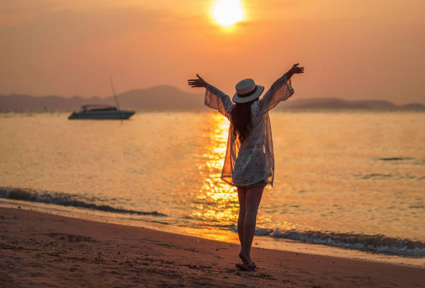 istock woman enjoy on sea beach with sunset 1015471316