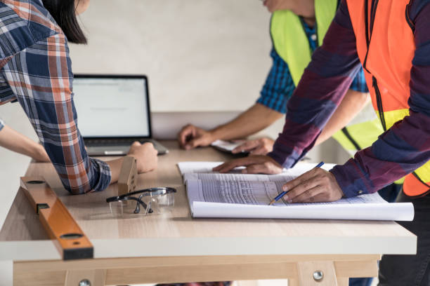 istock woman civil architect engineer discussion of building with building plan,engineering and architecture concept.Blue print is fake only for stock photo. 1015481518