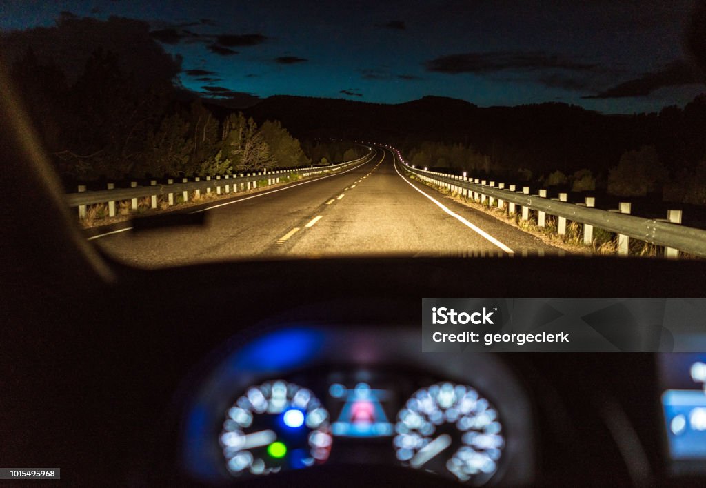 Country highway at night - Driver's point of view A curving country road in Utah, USA, illuminated by a car's headlights, with the car's dashboard in the foreground. Night Stock Photo