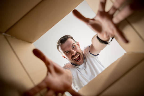 istock Man unpacking and opening carton box and looking inside 1015499794