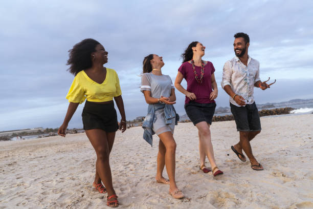 istock cheerful multi-ethnic friends walking at beach against sky 1015501220