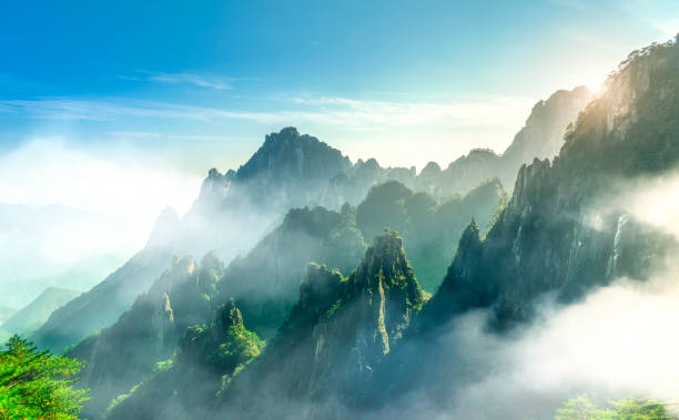 облако и туман в далеких горах горы хуаншань, китай - huangshan mountains стоковые фото и изображения
