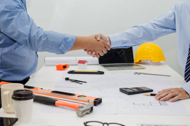 istock Architect and businessman shaking hands meeting discuss a plan about the construction project of real estate. Agreement and are willing to work together. 1015513014