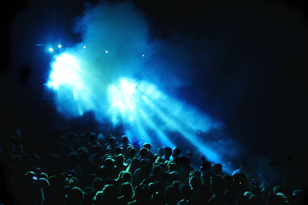 istock Concert crowd with blue laser lights and smoke 1015518486